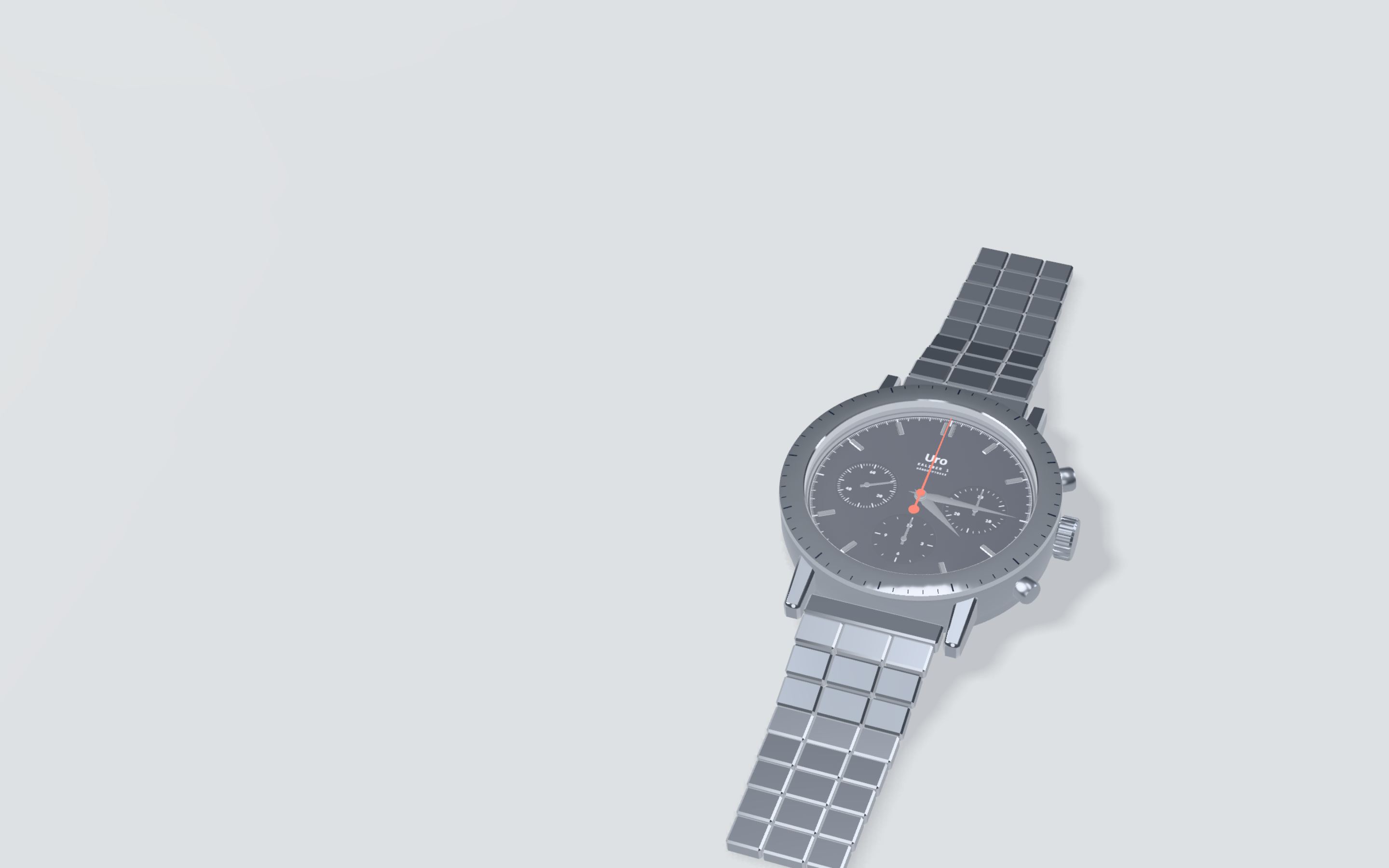 Uro Kaliber 1, a steel chronograph on a steel bracelet, lying still on pale grey.